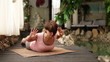 Girl doing Yoga  Cobra Pose spine exercise near Spa Center Pool