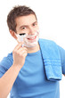 Photo: Portrait of a young man shaving his beard with a razor Portrait of a young man shaving his beard with a razor