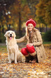 Photo: Smiling young woman posing with a labrador retriever out in a pa Smiling young woman posing with a labrador retriever out in a pa