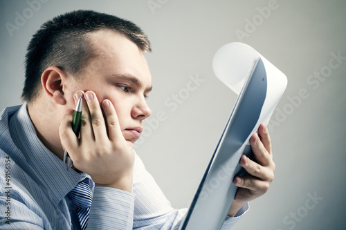 Photo: Businessman reading office document Businessman reading office document