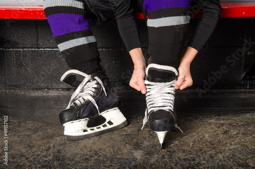 Photo: Child Tying Hockey Skates in Dressing Room Child Tying Hockey Skates in Dressing Room