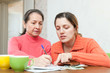 adult daughter helps the mother to fills in  bills