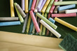 Foto: Multicoloured chalks and chalk eraser on the blackboard Multicoloured chalks and chalk eraser on the blackboard
