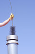 Cleaning chimney with sweeper sky background