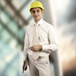 Photo: Young architect wearing a protective helmet standing on the buil Young architect wearing a protective helmet standing on the buil