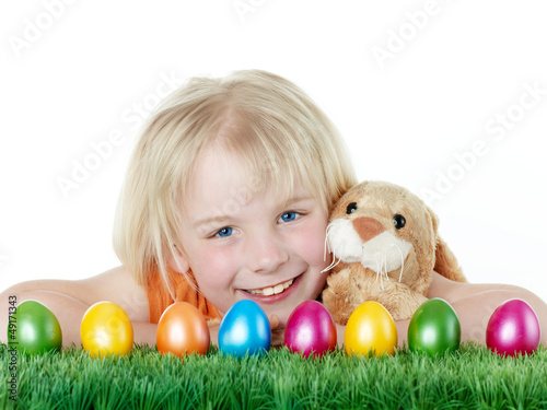 Photo: Cute blonde child is happy to have her Easter eggs and bunny Cute blonde child is happy to have her Easter eggs and bunny