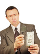 Serious man looks through a magnifying glass on the dollar