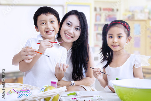 Photo: Family painting eggs in class Family painting eggs in class