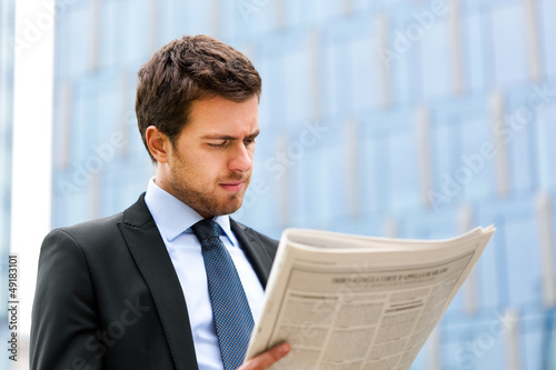 Photo: Handsome man reading a newspaper Handsome man reading a newspaper