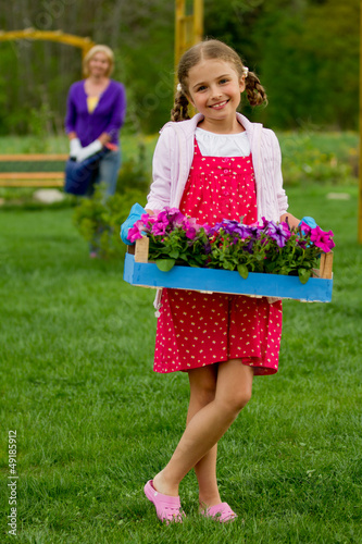 Photo: Gardening, planting - girl helping mother in the garden Gardening, planting - girl helping mother in the garden