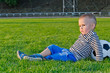 Little boy relaxing with his soccer ball