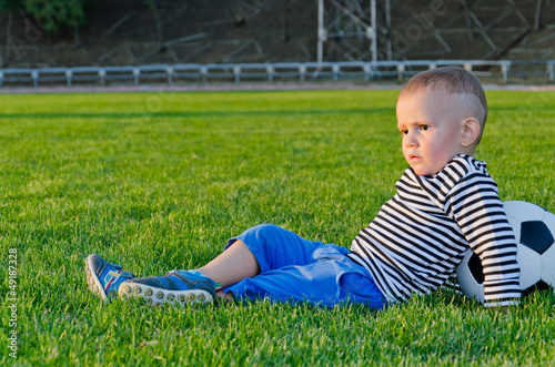 Photo: Little boy relaxing with his soccer ball Little boy relaxing with his soccer ball