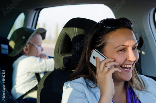 Photo: Woman driver laughing on her mobile phone Woman driver laughing on her mobile phone