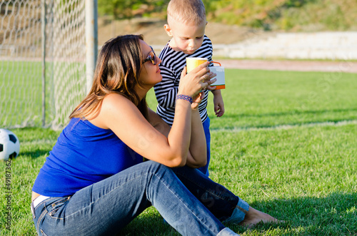 Photo: Mother giving her small son a drink Mother giving her small son a drink