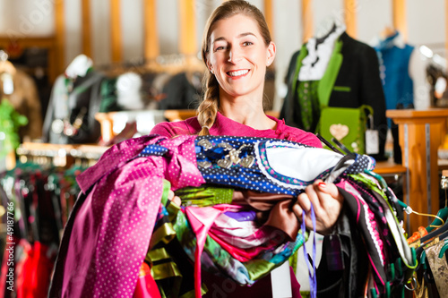 Photo: Woman is buying Tracht or dirndl in a shop Woman is buying Tracht or dirndl in a shop