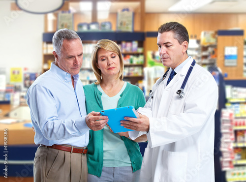 Photo: Pharmacist with a senior couple. Pharmacist with a senior couple.