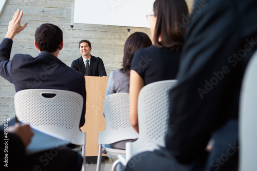 Photo: Businessman Delivering Presentation At Conference Businessman Delivering Presentation At Conference