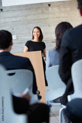 Photo: Businesswoman Delivering Presentation At Conference Businesswoman Delivering Presentation At Conference