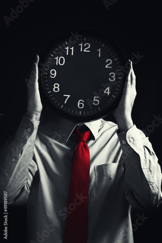 Photo: Businessman with black clock, deadline concept Businessman with black clock, deadline concept