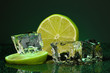 Ice cubes with lime on darck green background