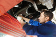 auto mechanic at wheel alignment work with spanner