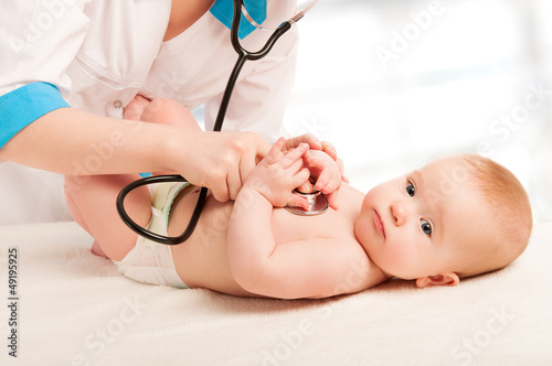 Photo: baby and doctor pediatrician. doctor listens to the heart with s baby and doctor pediatrician. doctor listens to the heart with s