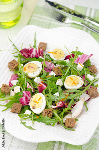 Photo: salad with quail eggs, feta and arugula, top view salad with quail eggs, feta and arugula, top view
