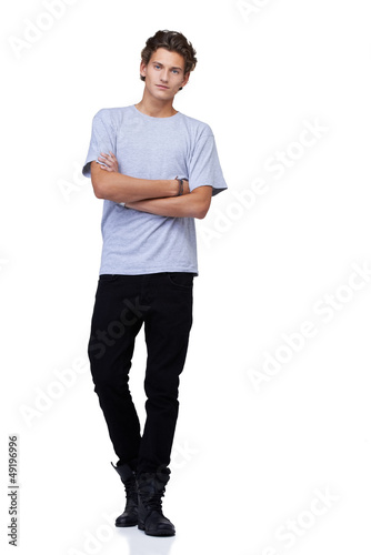 Photo: Handsome young guy standing against a white background with his Handsome young guy standing against a white background with his