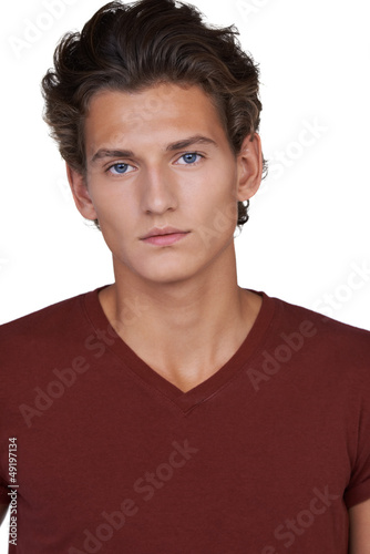 Photo: Serious young guy looking at you against a white background Serious young guy looking at you against a white background
