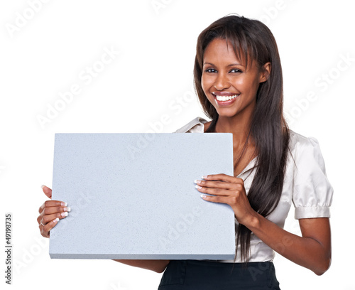 Photo: Studio shot of an attractive woman holding up a blank sign for c Studio shot of an attractive woman holding up a blank sign for c