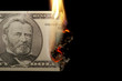 Burning dollar bill on a black