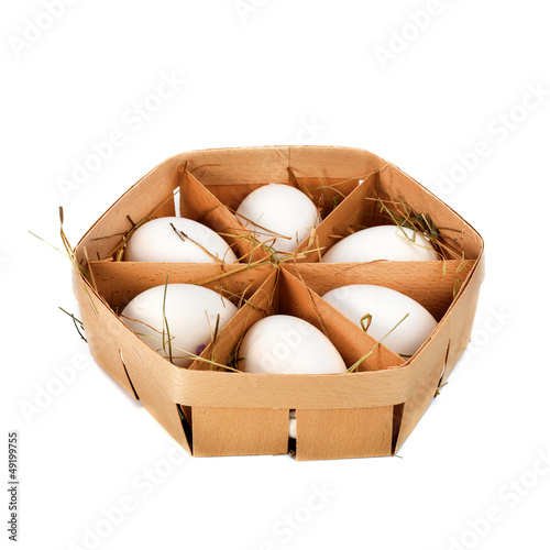Photo: eggs in a wooden container isolated on white eggs in a wooden container isolated on white