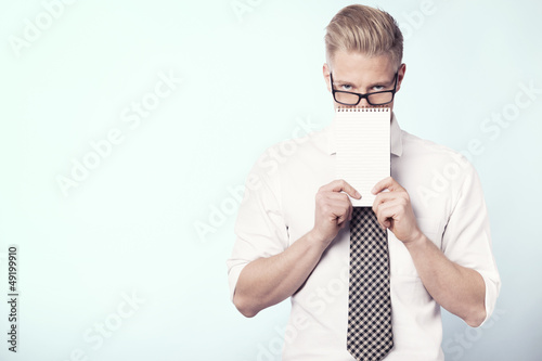 Photo: Young businessman presenting blank notepad. Young businessman presenting blank notepad.