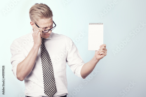 Photo: Likable businessman looking at empty notebook. Likable businessman looking at empty notebook.