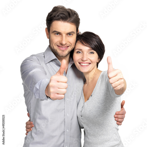 Photo: Portrait of happy couple with thumbs up sign Portrait of happy couple with thumbs up sign