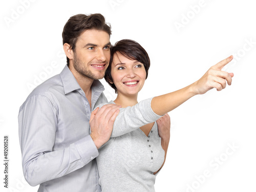 Photo: happy couple looking and pointing into the distance happy couple looking and pointing into the distance