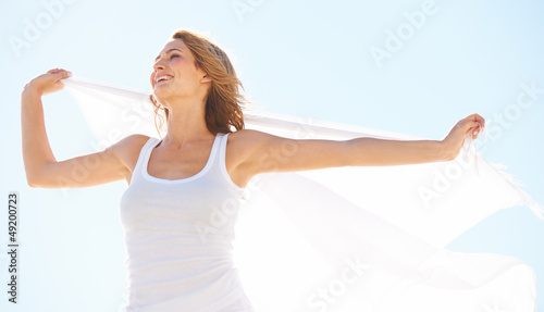 Photo: Beautiful blonde holding a white scarf behind her to blow in the Beautiful blonde holding a white scarf behind her to blow in the