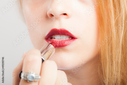 Photo: Woman applying lipstick Woman applying lipstick