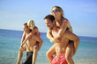Photo: Two young guys piggybacking their girlfriends on the beach Two young guys piggybacking their girlfriends on the beach