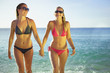 Two gorgeous young women in bikini's walking out of the ocean