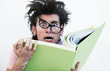 An extremely stressed hipster holding on to his study book with 
