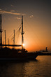 Sailing ship silhouetted against amber setting sun