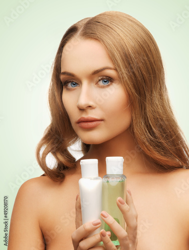 Photo: woman with cosmetic bottles woman with cosmetic bottles