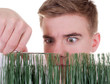 Teenager schneidet Gras mit Schere