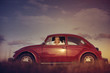 Red Volkswagen Beetle with beautiful woman inside.