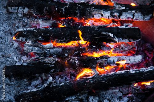 Photo: Burning wood and coal in fireplace. Closeup of hot burning wood Burning wood and coal in fireplace. Closeup of hot burning wood