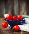 Dewy red tomatoes in blue bowl