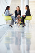Three Businesswomen Meeting Around Table In Modern Office