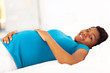 pregnant african american woman lying on bed