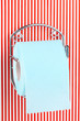 Roll of toilet paper on  holder fixed to pinstriped wall